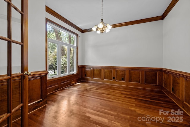 3932 Rounding Run Rd, Charlotte, NC 28277 - unfurnished room featuring ornamental molding, a chandelier, a wainscoted wall, and wood finished floors