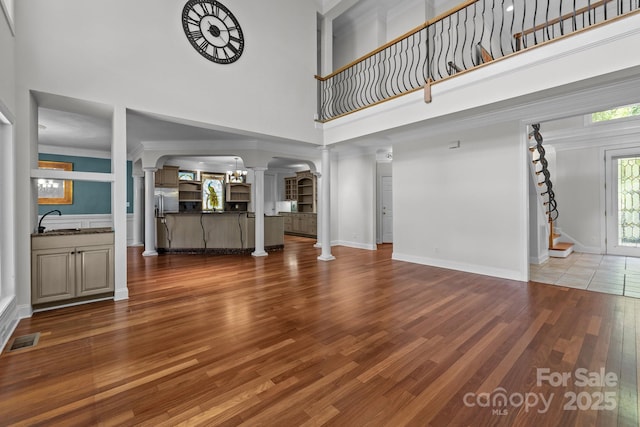 3932 Rounding Run Rd, Charlotte, NC 28277 - unfurnished living room with decorative columns, a high ceiling, wood finished floors, and arched walkways