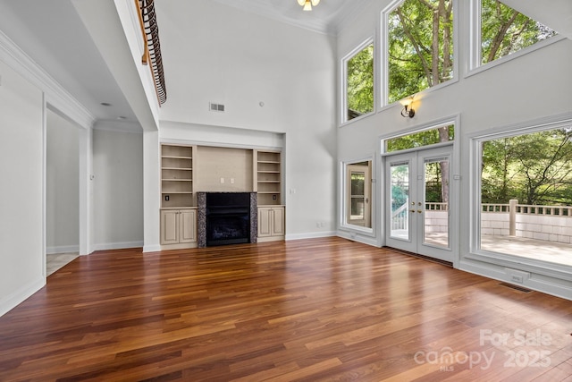 3932 Rounding Run Rd, Charlotte, NC 28277 - unfurnished living room featuring ornamental molding, healthy amount of natural light, wood finished floors, a high ceiling, and a fireplace