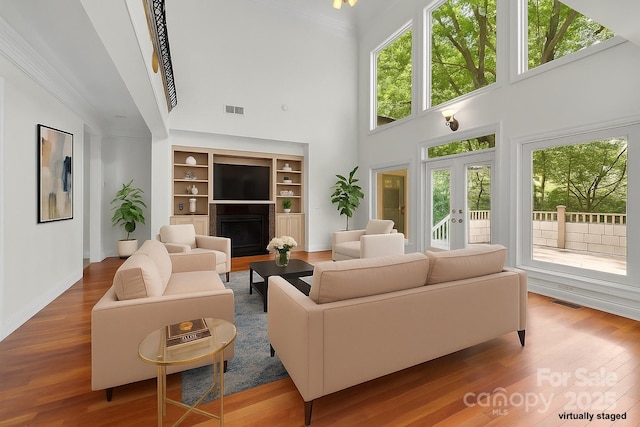 3932 Rounding Run Rd, Charlotte, NC 28277 - living area with a high ceiling, wood finished floors, a fireplace, plenty of natural light, and ornamental molding