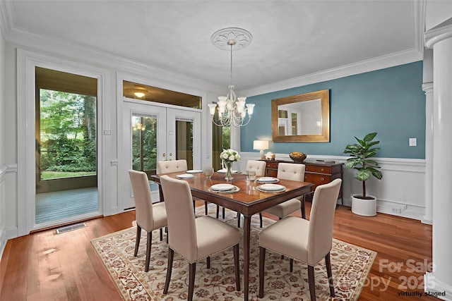 3932 Rounding Run Rd, Charlotte, NC 28277 - dining room with french doors, a chandelier, wood finished floors, crown molding, and a wainscoted wall