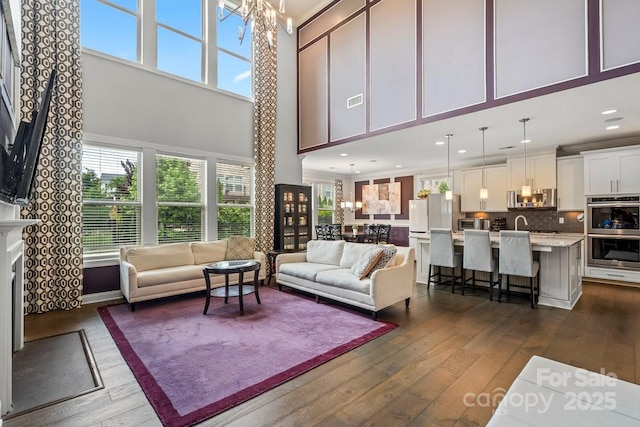 8514 Ellington Park Dr, Charlotte, NC 28277 - living room with a towering ceiling, dark wood-style flooring, a chandelier, plenty of natural light, and recessed lighting