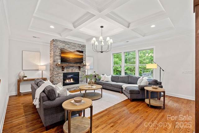 living area featuring baseboards, light wood finished floors, coffered ceiling, beam ceiling, and a stone fireplace