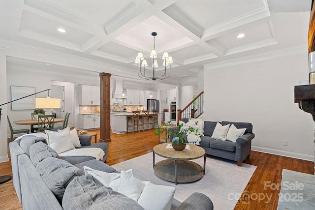 living area with a chandelier, stairway, ornamental molding, coffered ceiling, and baseboards