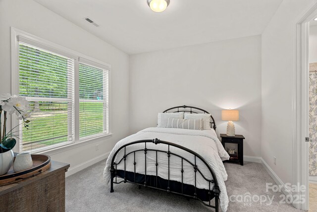 bedroom featuring light carpet and baseboards