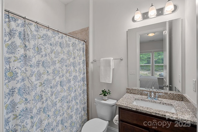 bathroom with ensuite bathroom, vanity, toilet, and curtained shower