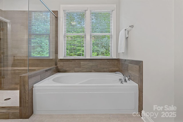full bathroom featuring a bath, a tile shower, and tile patterned flooring