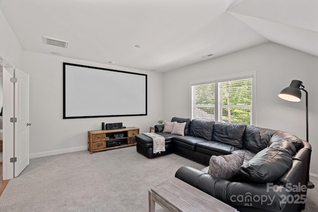 carpeted cinema featuring lofted ceiling and baseboards
