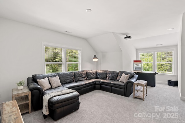 carpeted living room with plenty of natural light, vaulted ceiling, and baseboards