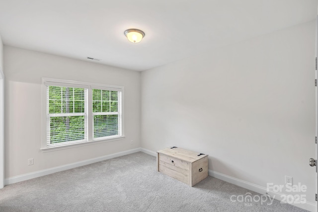 spare room with baseboards and carpet flooring