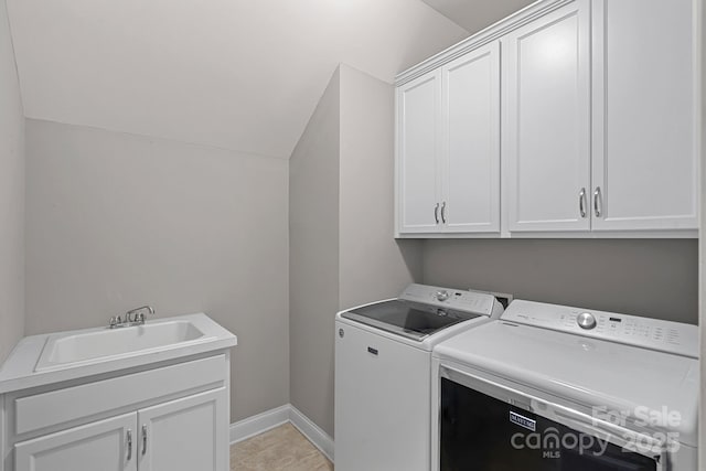 clothes washing area with cabinet space, washing machine and clothes dryer, and baseboards