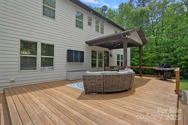 wooden terrace featuring an outdoor hangout area, grilling area, and ceiling fan