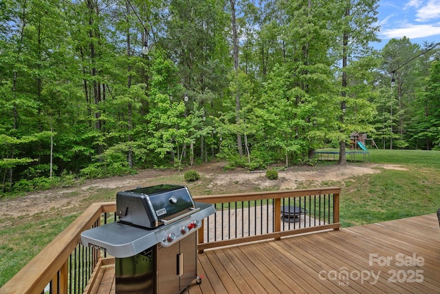 wooden terrace with a playground and a yard