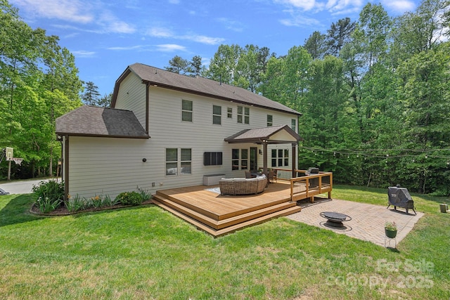 rear view of house with a fire pit, a wooden deck, a yard, a shingled roof, and a patio