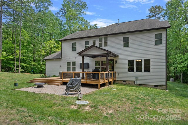 back of property with crawl space, a wooden deck, and a lawn