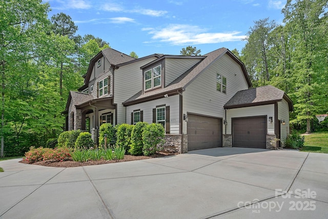 view of front of home with stone siding, concrete driveway, a shingled roof, and a garage