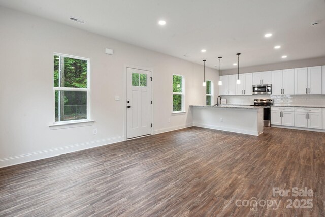 746 Shasta St NW, Concord, NC 28027 - kitchen with stainless steel appliances, dark wood-style flooring, a sink, white cabinets, and open floor plan