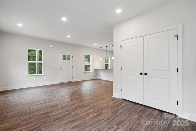 746 Shasta St NW, Concord, NC 28027 - unfurnished living room with healthy amount of natural light, dark wood-style floors, recessed lighting, and baseboards