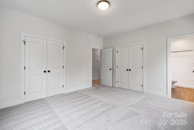 746 Shasta St NW, Concord, NC 28027 - unfurnished bedroom featuring two closets, carpet flooring, baseboards, and connected bathroom