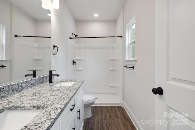 746 Shasta St NW, Concord, NC 28027 - bathroom featuring wood finished floors, baseboards, a shower, toilet, and double vanity