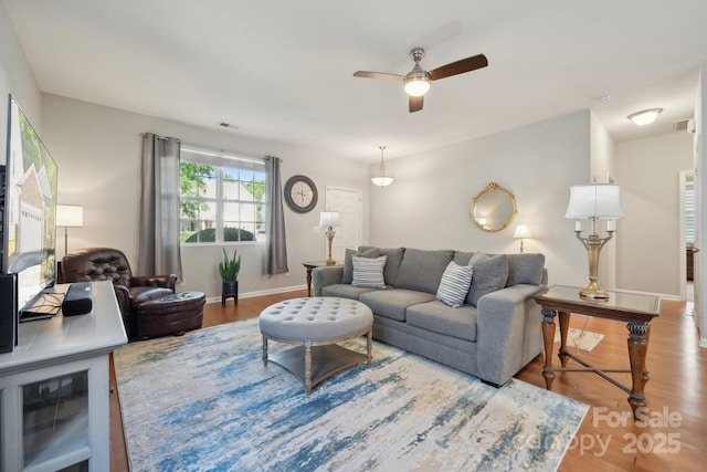 living room featuring wood finished floors, ceiling fan, and baseboards