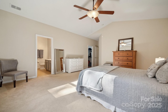 carpeted bedroom featuring a spacious closet, lofted ceiling, a closet, ensuite bathroom, and ceiling fan