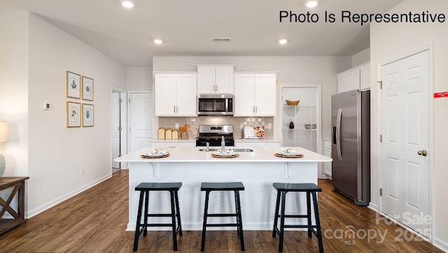 131 Meadow View Dr, Statesville, NC 28677 - kitchen with appliances with stainless steel finishes, a sink, light countertops, a kitchen bar, and an island with sink