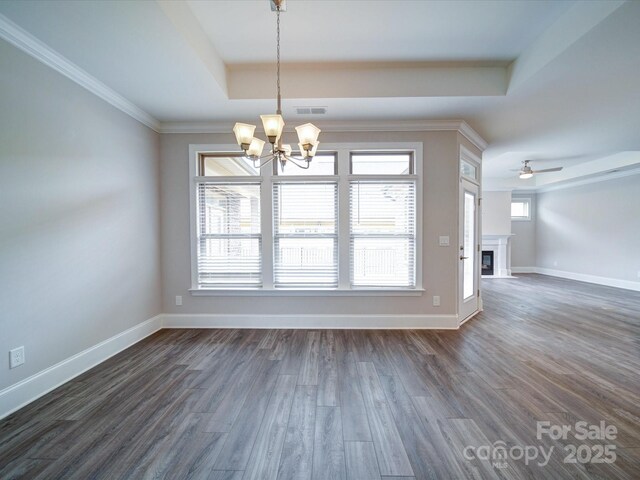 405 Newstyle Way, Gastonia, NC 28056 - unfurnished dining area with a raised ceiling, a chandelier, dark wood-style flooring, baseboards, and a glass covered fireplace