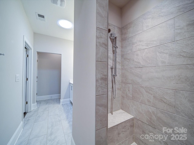 405 Newstyle Way, Gastonia, NC 28056 - bathroom featuring a tile shower, marble look tiles, vanity, and baseboards