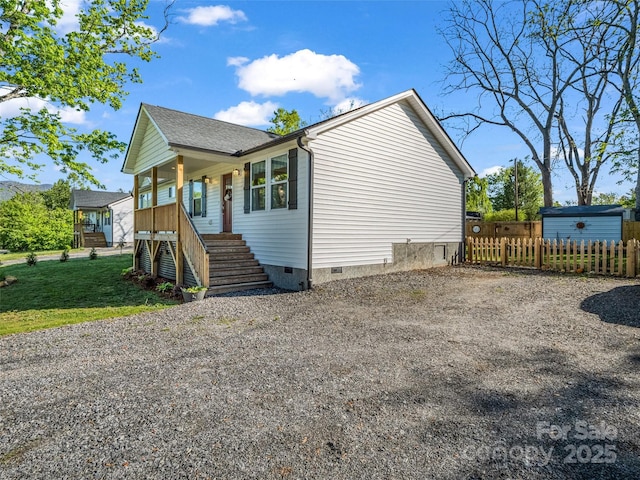view of front of property with crawl space, stairway, a porch, and driveway