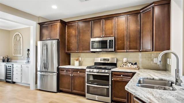 7324 Jolly Brook Dr, Charlotte, NC 28215 - kitchen featuring stainless steel appliances, a sink, wine cooler, light stone countertops, and backsplash