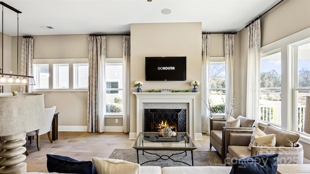 7324 Jolly Brook Dr, Charlotte, NC 28215 - living room with a lit fireplace, baseboards, and stone finish floors