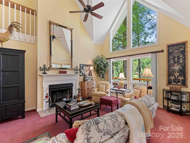 living area featuring high vaulted ceiling, a ceiling fan, carpet, a fireplace with flush hearth, and baseboards
