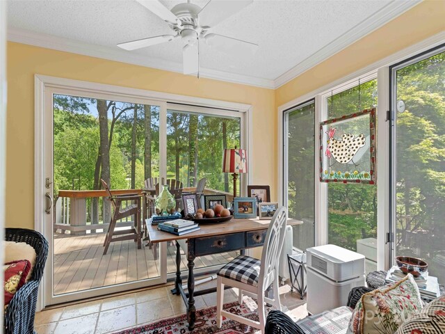 sunroom / solarium featuring healthy amount of natural light, crown molding, a textured ceiling, and stone tile floors