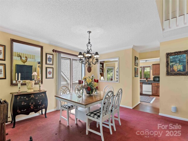 dining room with a chandelier, dark carpet, a textured ceiling, ornamental molding, and baseboards