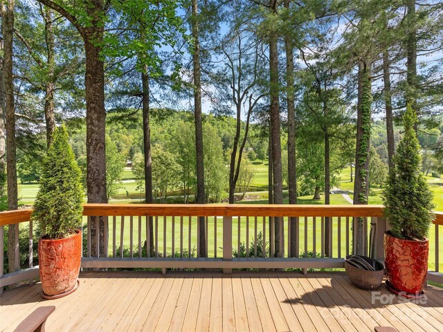 wooden deck with view of scattered trees
