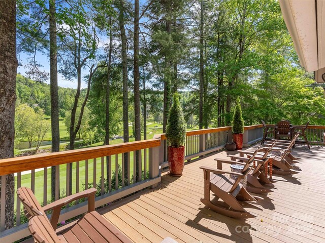 wooden deck featuring view of wooded area