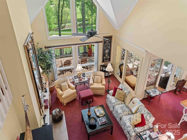 living area featuring a ceiling fan, healthy amount of natural light, high vaulted ceiling, and tile patterned flooring