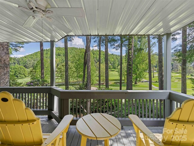 sunroom / solarium with ceiling fan, healthy amount of natural light, and golf course view