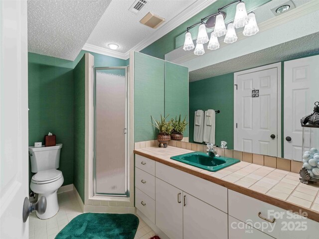 bathroom with a stall shower, crown molding, a textured ceiling, vanity, and tile patterned flooring