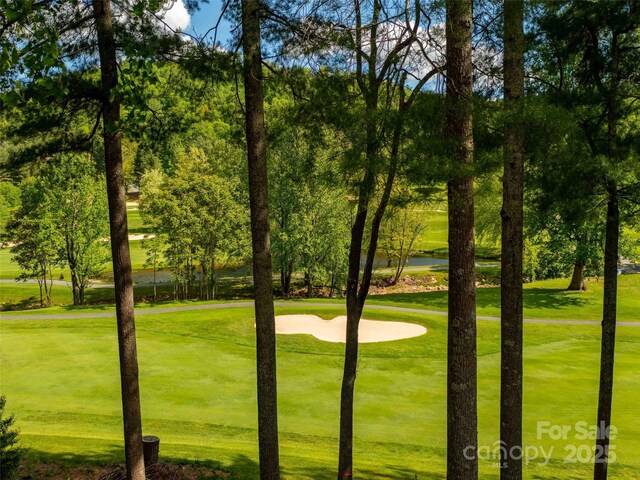 view of property's community featuring golf course view and a yard