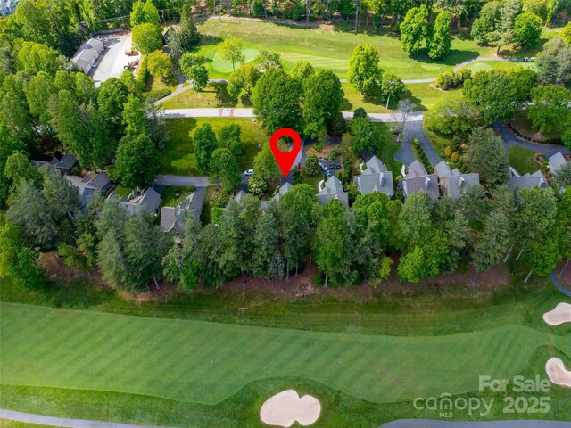 aerial overview of property's location with a tree filled landscape and a golf course