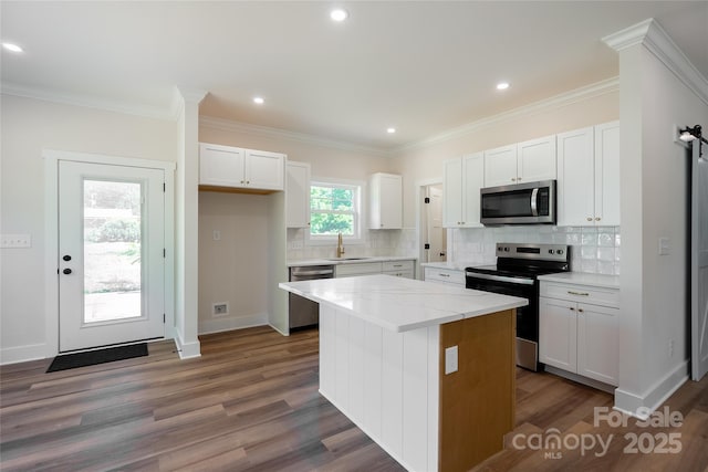 7426 Hambright Rd, Huntersville, NC 28078 - kitchen featuring appliances with stainless steel finishes, a sink, wood finished floors, white cabinetry, and recessed lighting