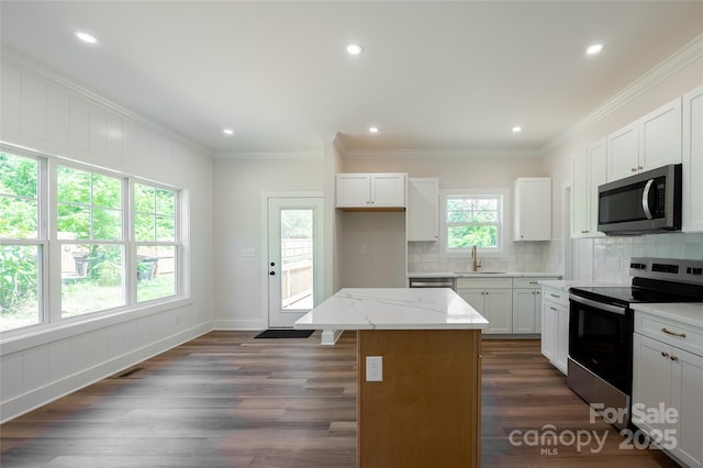 7426 Hambright Rd, Huntersville, NC 28078 - kitchen featuring stainless steel appliances, backsplash, a sink, a center island, and ornamental molding
