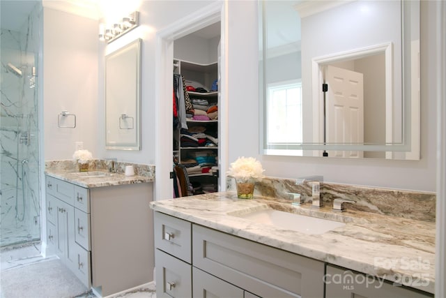 full bath with a marble finish shower, vanity, a walk in closet, and crown molding