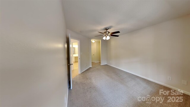 unfurnished room featuring baseboards, ceiling fan, and carpet