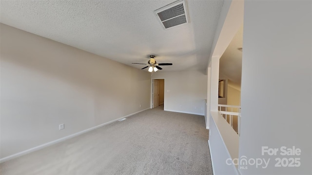 spare room with carpet flooring, ceiling fan, a textured ceiling, and baseboards