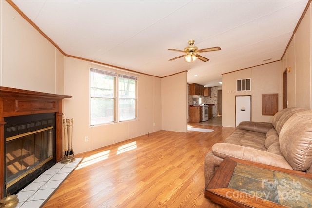 283 Grandview Dr Unit 1, Marshall, NC 28753 - living room with crown molding, light wood finished floors, a tiled fireplace, ceiling fan, and vaulted ceiling
