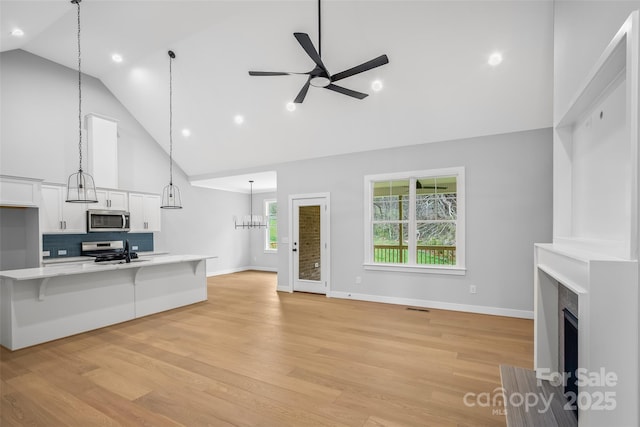 149 Beauchamp Oaks Ct, Advance, NC 27006 - unfurnished living room featuring high vaulted ceiling, ceiling fan, a fireplace with flush hearth, light wood-type flooring, and baseboards