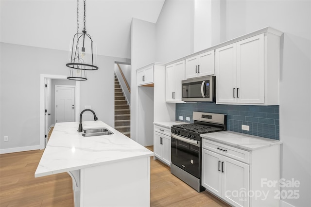 149 Beauchamp Oaks Ct, Advance, NC 27006 - kitchen with appliances with stainless steel finishes, a sink, a kitchen island with sink, white cabinetry, and high vaulted ceiling